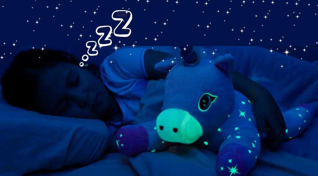 A girl sleeping at night with Glimmer the Glowing Unicorn gently glowing